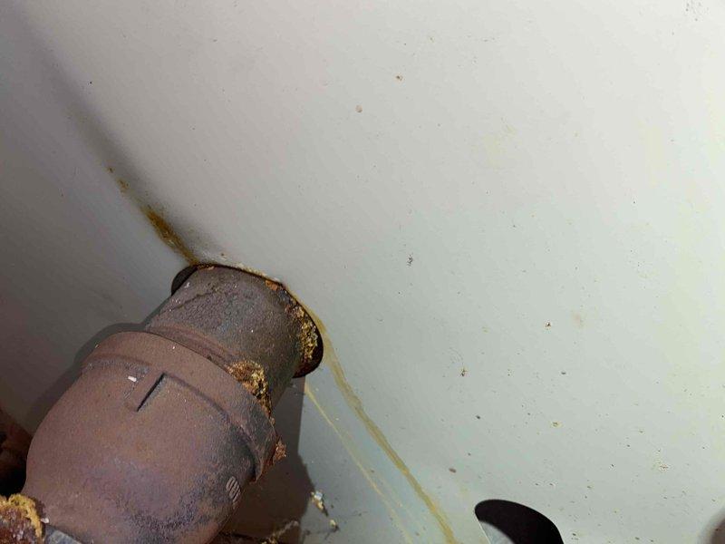 Responded to service call for no heat from aging steam radiator system. Inspection revealed significant corrosion and deterioration at pipe connections, particularly at the main elbow joint where protective insulation has degraded. System restored to operation after clearing blockage and replacing damaged valve components.