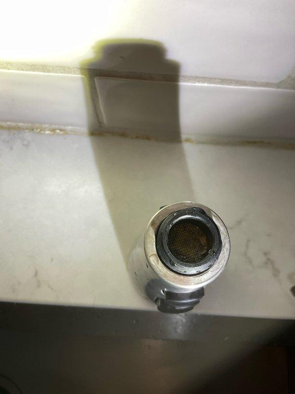 Responded to service call for leaky faucet in century-old residential property. Upon inspection, identified mineral buildup in the aerator screen and wear on valve components causing the leak. Disassembled fixture, cleaned mineral deposits, replaced worn gaskets and reassembled, confirming proper operation with no further leakage.