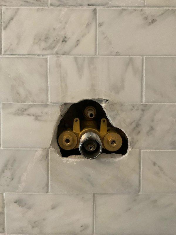 Replaced master shower valves through front access point, requiring precision cutting through marble tile surface. Installation included proper fitting of brass inlet valves and chrome control valve assembly. Also serviced and verified proper connection of the AP917HD-S water filtration system in utility area.