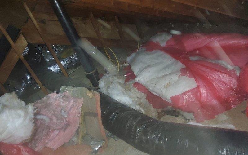 Inspected attic ductwork and identified multiple holes in the ducts allowing external debris infiltration. Documented damaged sections with photos showing compromised insulation around the ductwork and an affected ceiling register/vent in what appears to be a residential room. Further repairs recommended to prevent continued contamination of the HVAC system.