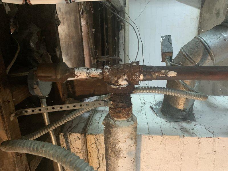 Inspected 13-year-old steam boiler system to provide estimate for pipe replacement. Documented extensive corrosion and mineral deposits on existing copper piping, particularly at valve junctions, with visible water damage to surrounding areas. Noted previous partial replacement with PVC piping, but recommended complete replacement of remaining deteriorated copper sections to prevent potential failure.