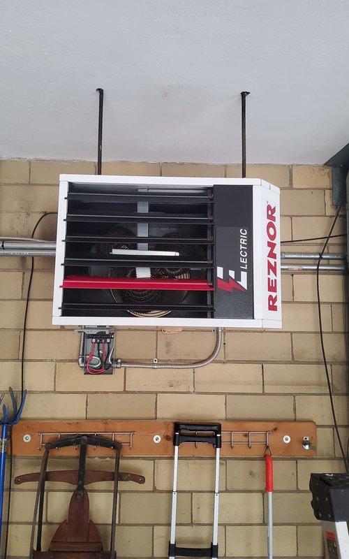 Performed diagnostic check on Reznor electric garage heater as requested. Inspected unit mounted on brick wall and verified electrical connections at Eaton disconnect switch. Confirmed proper operation of heating element and ventilation system.