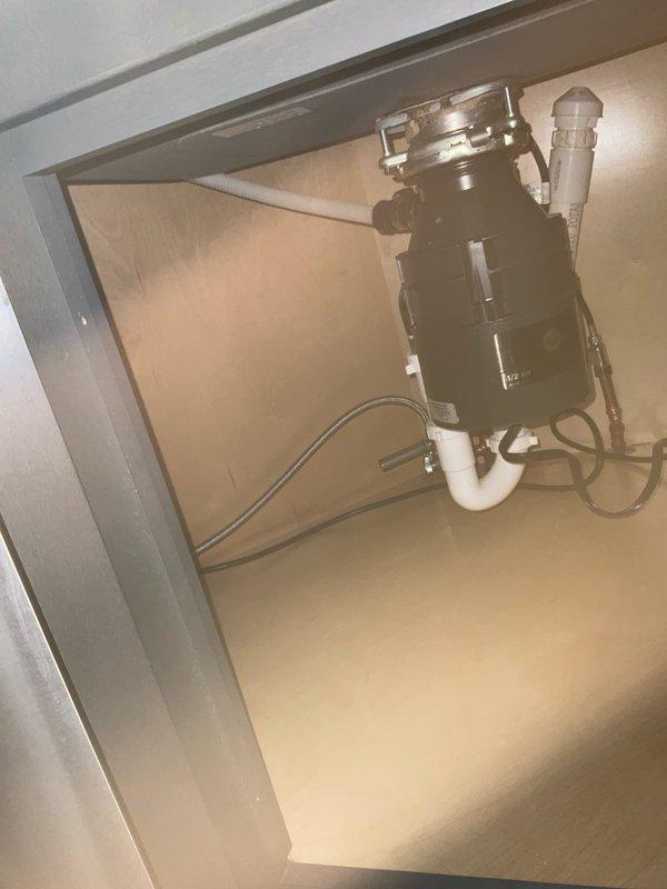 Responded to callback regarding garbage disposal leak following a previous under-sink water leak repair. Inspected InSinkErator unit and connections, identifying issue at the drain assembly where water was seeping through. Tightened connections and verified proper operation with no further leakage detected.