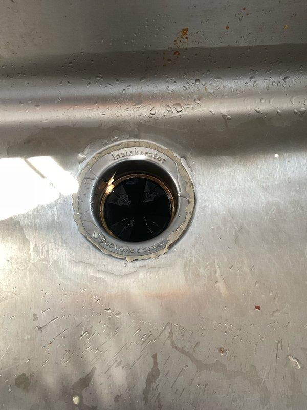 Responded to callback regarding garbage disposal leak following a previous under-sink water leak repair. Inspected InSinkErator unit and connections, identifying issue at the drain assembly where water was seeping through. Tightened connections and verified proper operation with no further leakage detected.