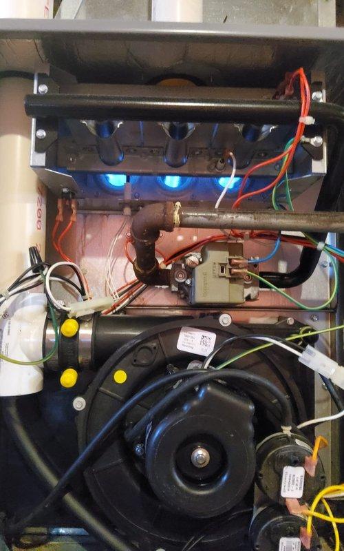 Responded to no heat call for 12-year-old Kenmore furnace where thermostat was not turning on. Diagnosed and repaired faulty wiring connections in the control circuit, restoring proper ignition sequence as evidenced by even blue flame pattern across burner assembly. System now operating normally with blower motor circulating heated air effectively.