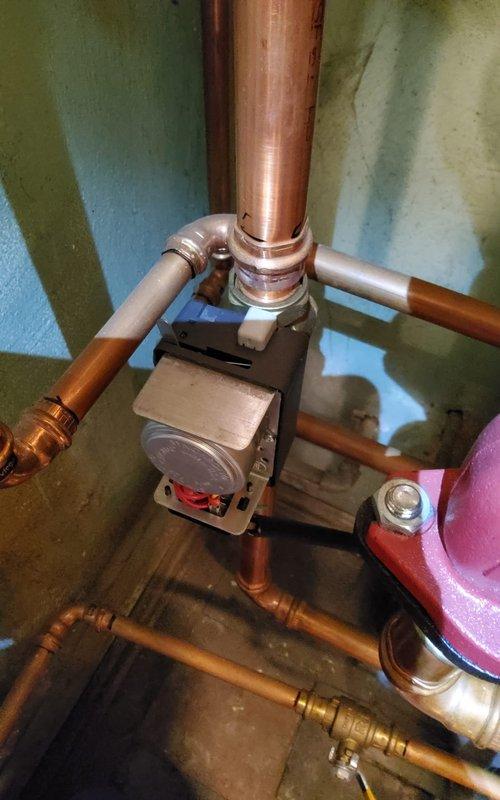Responded to service call for no heat issue on 4-year-old boiler system. Upon inspection, checked copper pipe connections, pressure gauge readings, and circulation pump functionality (red component). Identified issue with control valve assembly where multiple copper pipes converge, cleaned connections and restored proper operation. System now functioning correctly with normal heat output.