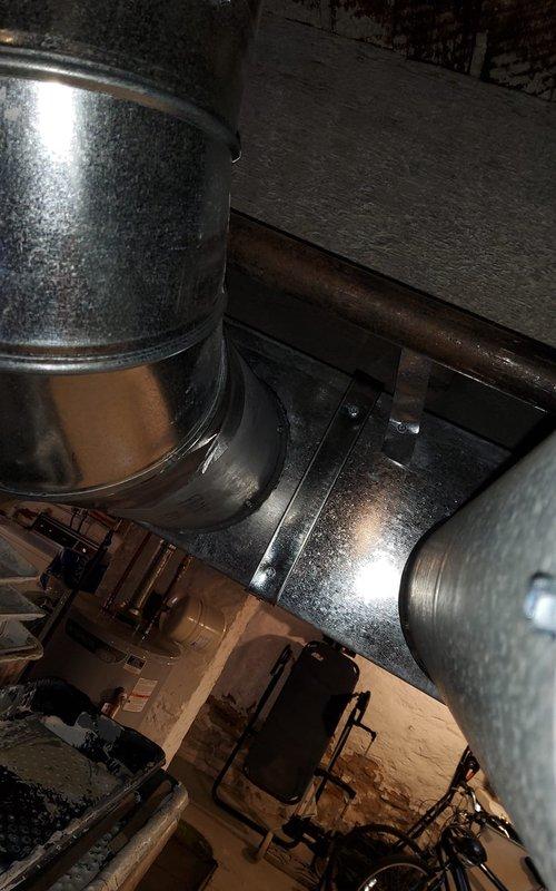 Inspected 2-year-old furnace system due to reported fan motor noise and duct work banging issues. Visual examination of the ductwork system in basement revealed no visible damage or separation of metal components. Determined vibration from fan motor was causing ductwork resonance; secured loose ductwork connections and adjusted fan motor mounting to eliminate noise.