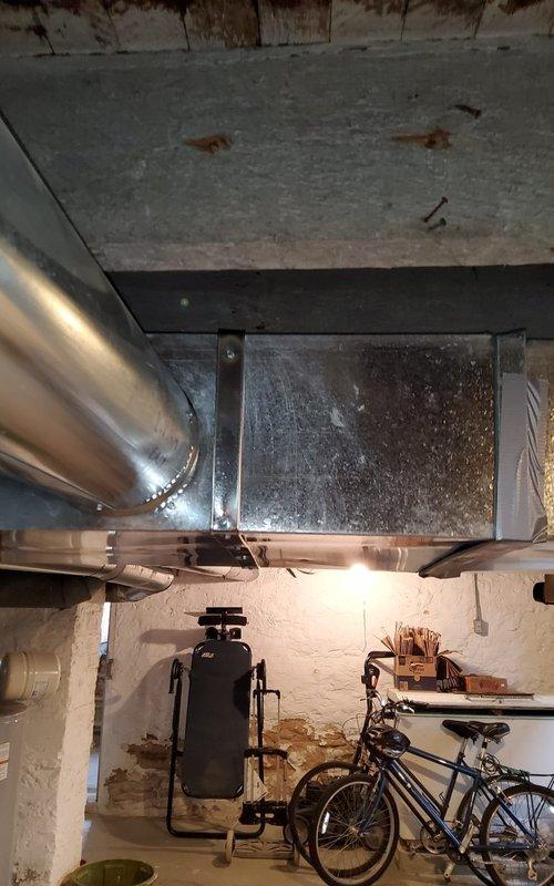 Inspected 2-year-old furnace system due to reported fan motor noise and duct work banging issues. Visual examination of the ductwork system in basement revealed no visible damage or separation of metal components. Determined vibration from fan motor was causing ductwork resonance; secured loose ductwork connections and adjusted fan motor mounting to eliminate noise.