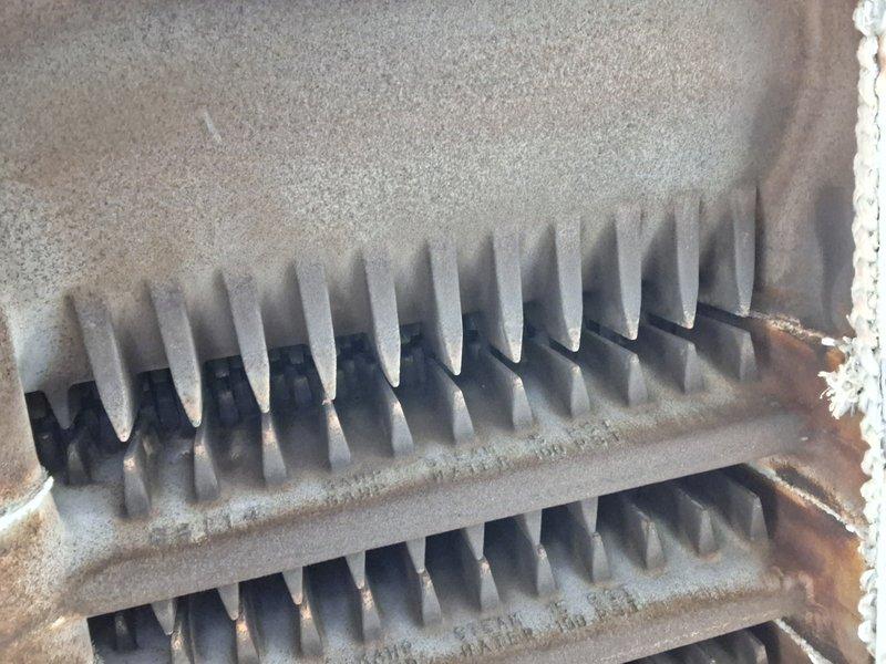 Performed routine heating maintenance inspection. Observed significant rust and corrosion on ventilation grill with poor sealing to surrounding surface. Heat exchanger fins showed dust accumulation requiring cleaning to improve thermal efficiency and system performance.