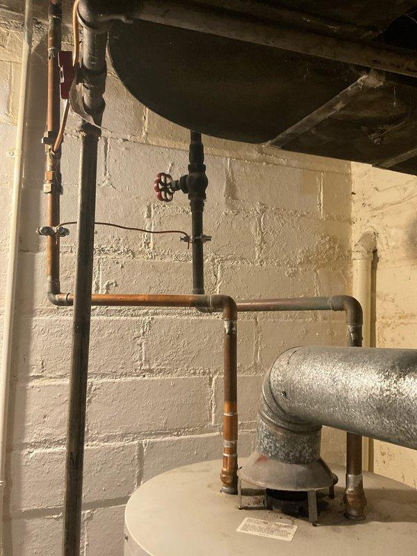 Responded to emergency service call for water heater failure. Discovered aging water heater with catastrophic leak from bottom of tank causing significant water damage to basement utility area. Provided quote for immediate replacement of the failed unit.
