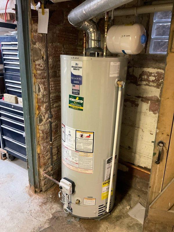 Successfully installed a new Bradford White tanked water heater in basement utility area, replacing the existing unit. Connected all necessary copper water lines, properly vented with metal ductwork, and installed expansion tank above the unit according to manufacturer specifications.