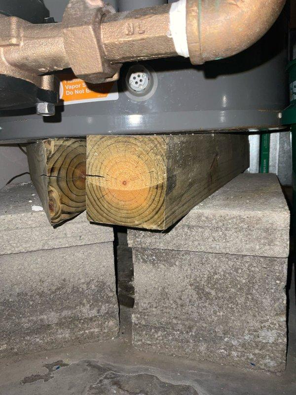 Responded to service call for 20-year-old tanked water heater system. Performed inspection of the existing installation, noting aging copper pipes with visible corrosion and inadequate support structure consisting of pressure-treated lumber resting on concrete blocks. Installed VIP expansion tank to address pressure regulation issues and replaced failing components on the Classic-branded water heater to restore proper functionality.