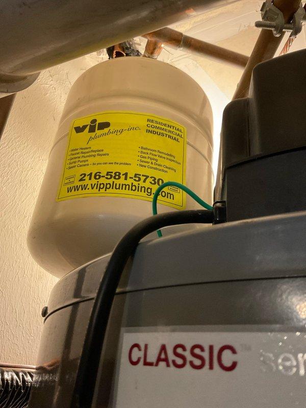 Responded to service call for 20-year-old tanked water heater system. Performed inspection of the existing installation, noting aging copper pipes with visible corrosion and inadequate support structure consisting of pressure-treated lumber resting on concrete blocks. Installed VIP expansion tank to address pressure regulation issues and replaced failing components on the Classic-branded water heater to restore proper functionality.