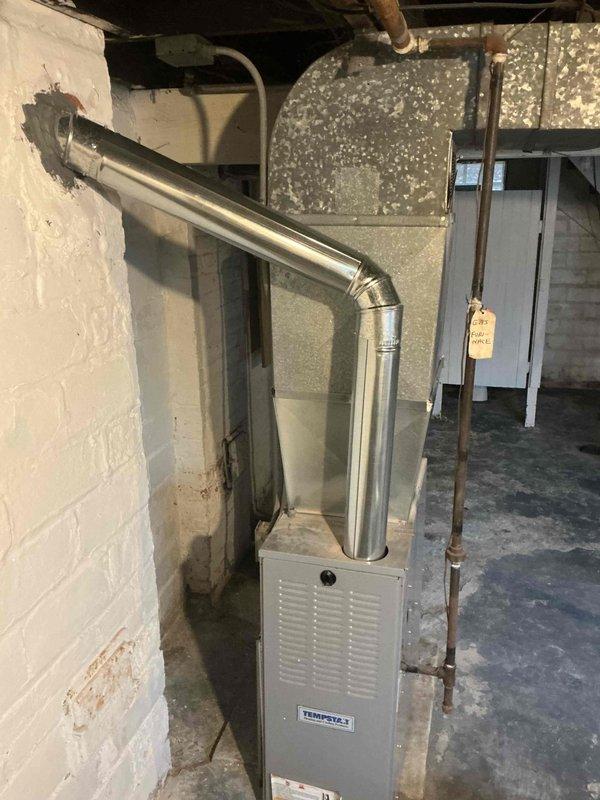 Successfully completed replacement of deteriorated flue pipes on Tempstar furnace, ensuring proper exhaust venting through exterior wall. New metal exhaust pipe with appropriate 90-degree bend was installed and sealed at wall penetration for safe and efficient operation.