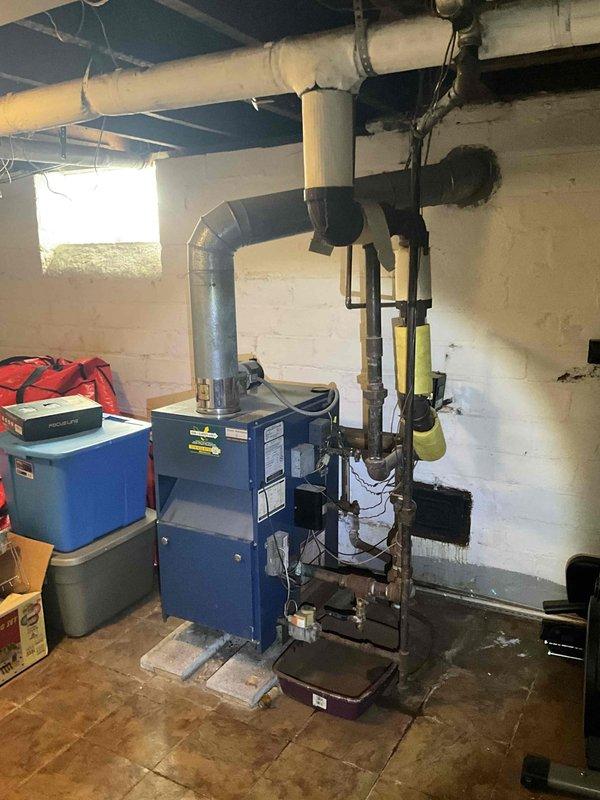 Responded to no-heat call for residential boiler system of unknown age located in basement mechanical room. Upon inspection, evaluated existing blue boiler unit with associated piping, flue system, and connections. Documented current equipment condition and configuration, including copper supply lines, yellow-insulated piping sections, metal ductwork, and venting system. Provided comprehensive estimate for complete boiler replacement to restore heating functionality to the property.