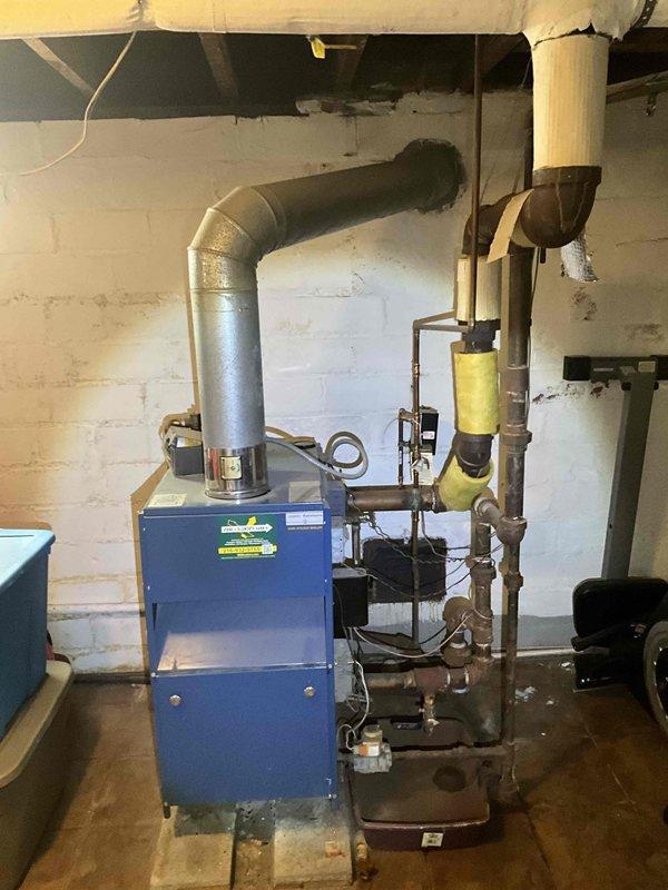 Responded to no-heat call for residential boiler system of unknown age located in basement mechanical room. Upon inspection, evaluated existing blue boiler unit with associated piping, flue system, and connections. Documented current equipment condition and configuration, including copper supply lines, yellow-insulated piping sections, metal ductwork, and venting system. Provided comprehensive estimate for complete boiler replacement to restore heating functionality to the property.