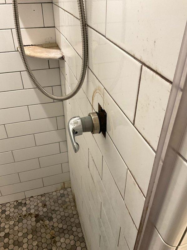 Responded to multiple plumbing issues throughout the residence. Cleared slow drains in the first-floor half bath, primary bathroom sink, and guest bathroom sink and tub using appropriate drain cleaning methods. Inspected and addressed the leaking showerhead in the primary bathroom, examining the shower arm mount and connection points where deterioration and gaps around the wall fixture were observed. Evaluated the faulty diverter lever on the guest bathroom tub faucet that controls water flow between the tub spout and showerhead. Additionally assessed the kitchen refrigerator water supply line to diagnose the water and ice dispenser malfunction. Documented conditions with photos showing shower fixture mounting concerns and tile grout deterioration requiring attention.