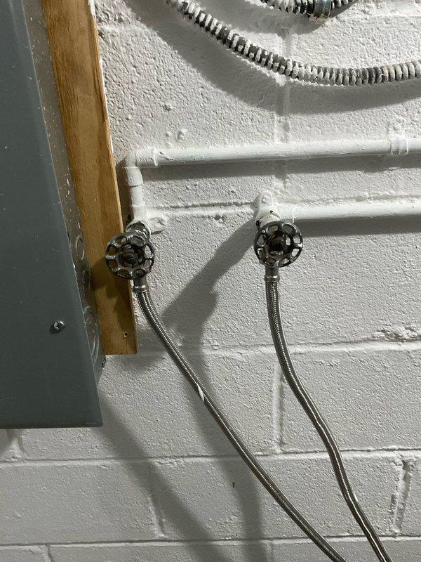 Responded to service call for leaking main water valve in basement. Upon arrival, inspected the main shut-off valves and plumbing manifold system. The chrome-handled wheel-style shut-off valves showed signs of active leaking at the connection points. Documented existing conditions including the PEX manifold distribution system, copper supply lines, and main valve assembly. Performed assessment of the leak source and surrounding plumbing infrastructure to determine necessary repairs.