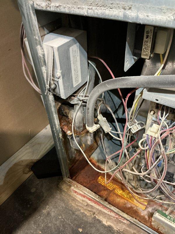 Completed comprehensive tune-up on 15-year-old residential furnace system. Performed standard maintenance protocol including inspection of all internal components, electrical connections, and wiring integrity. Noted significant rust and corrosion present on metal piping and internal compartment surfaces, indicating moisture exposure over time. Observed accumulated dust and debris throughout cabinet, which was cleaned during service. Verified proper operation of transformer, relay components, and all electrical connections. Inspected exterior condensing unit, noting deteriorated top panel with organic growth, environmental debris accumulation, and mildew present on surfaces. Unit currently operating within normal parameters despite age-related wear and corrosion issues. Recommended monitoring moisture sources contributing to internal rust formation and consideration of future component replacement due to advanced corrosion. System left in proper working condition with all safety checks 