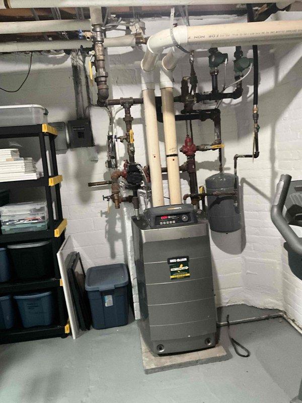 Conducted on-site boiler estimate in basement mechanical room. Evaluated existing heating system including modern boiler unit with digital display, extensive PVC piping network with multiple zone valves, aged gas supply line with Boston flexible connector, and associated plumbing infrastructure. Documented current system configuration and component conditions through photographic assessment for replacement proposal.