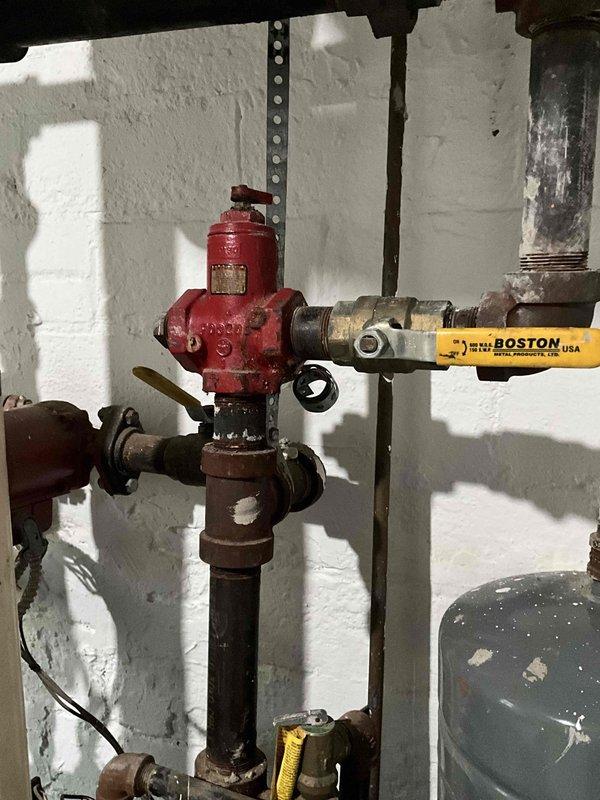 Conducted on-site boiler estimate in basement mechanical room. Evaluated existing heating system including modern boiler unit with digital display, extensive PVC piping network with multiple zone valves, aged gas supply line with Boston flexible connector, and associated plumbing infrastructure. Documented current system configuration and component conditions through photographic assessment for replacement proposal.