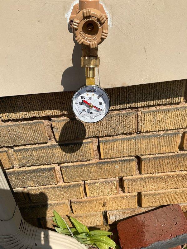 Responded to customer report of water hammer (banging pipes) that began following exterior water shutoff work. Installed pressure gauge on exterior hose bib to diagnose system pressure issues potentially contributing to both the pipe noise and previously reported running toilet. Pressure reading indicated near-zero static pressure at exterior fixture, suggesting possible pressure regulation concerns that may require further investigation to resolve both the water hammer condition and toilet fill valve operation.