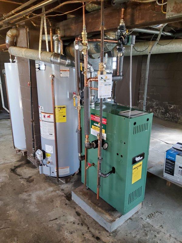 Completed installation of new hot water boiler system for second floor apartment heating. Removed and replaced existing boiler with new green unit mounted on concrete pad in basement mechanical room. Installed new thermostat, expansion tank, backflow preventer/PRV combination valve, vertical air eliminator, and circulating pump. Removed obsolete ceiling-mounted expansion tank from overhead joists. Connected all components using existing 3/4 inch copper supply lines with new brass fittings and valves. Verified proper operation of all controls, tested system pressure, purged air from lines, and confirmed adequate heat delivery to second floor zone. All equipment secured and operational per manufacturer specifications.