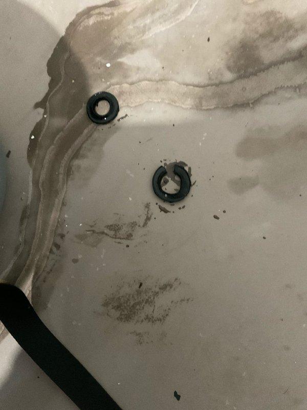 Responded to reported valve leak on plumbing assembly. Upon inspection, identified active leak at valve fitting connection point on wall-mounted system. Placed absorbent material beneath assembly to contain water discharge during evaluation. Assessed valve condition, surrounding pipe connections, and mounting hardware for integrity. Documented existing conditions including mineral deposits and water staining in collection pan, indicating ongoing leak activity. Captured photographic evidence of valve assembly configuration and leak source for service records.