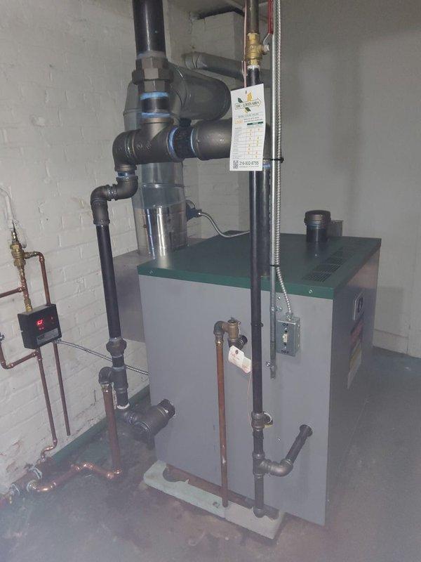 Completed full steam boiler system replacement in mechanical room. Installed new steam boiler with associated components including backflow preventer, automatic feeder, and White-Rodgers digital thermostat. Replaced existing Hartford loop due to multiple leak points. Reused existing vaporstat and connected to 3" black pipe supply and 3" main. Replaced three smaller-style steam vents on return lines. Removed improperly installed main vent that was tapped directly into pipe, repaired piping to meet proper installation standards, and installed new main vent in correct configuration. All copper and black iron piping connections completed with proper shut-off valves. System tested and operational upon completion.
