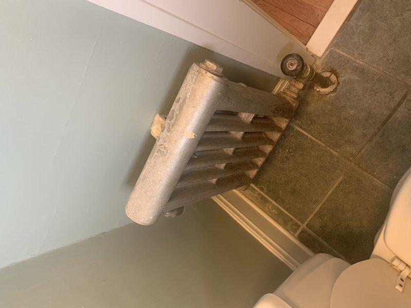 Conducted on-site estimate for boiler system replacement. Documented existing heating distribution system including cast iron radiators and baseboard radiators throughout residence, noting accumulation of dust and debris on heating units requiring attention during installation phase.