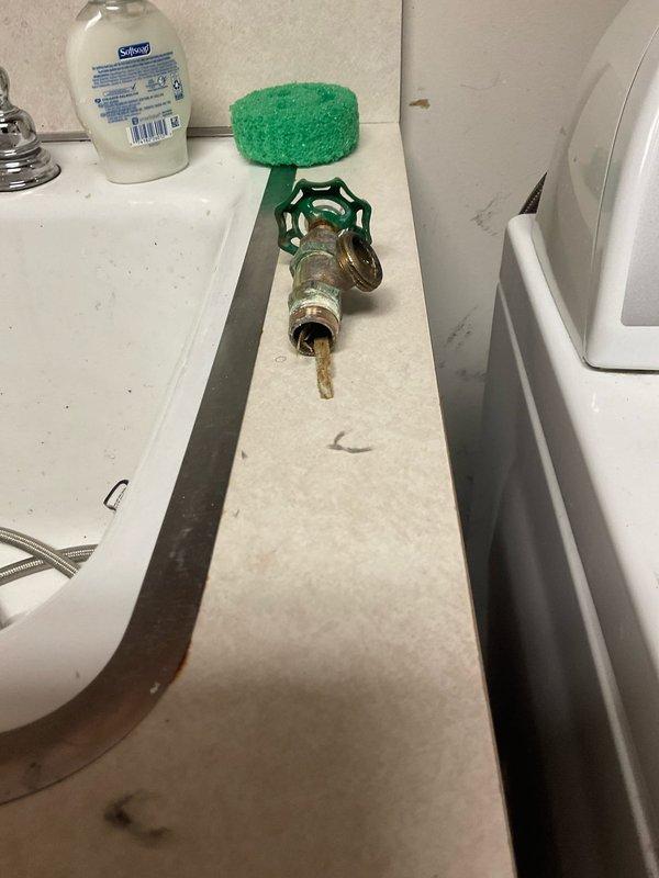 Responded to commercial plumbing service call and assessed multiple repair needs. Documented existing conditions including an improperly located outdoor hose bib installed on bathroom sink ledge and water-damaged flooring surrounding toilet flange with visible staining indicating previous leak or moisture intrusion. Provided estimates for necessary repairs to address code violations and water damage remediation.