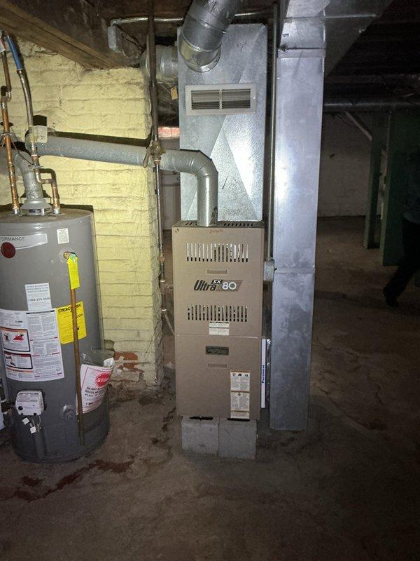 Conducted site assessment for add-on air conditioning system installation at duplex property with separate upper and lower units. Evaluated existing HVAC infrastructure including Ultra 80 furnace, electrical panel capacity, ductwork configuration, and mechanical room layout to determine feasibility and requirements for dual AC system integration. Documented current equipment conditions and spatial constraints in basement utility area to prepare comprehensive replacement estimate.