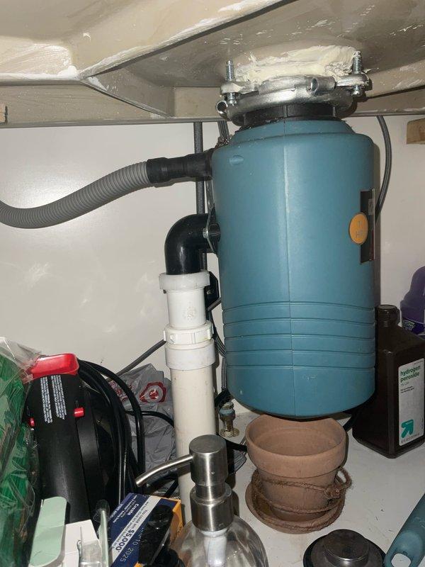 Responded to service call for garbage disposal leak beneath kitchen sink. Upon inspection, identified small leak at disposal mounting flange connection to sink basin. Tightened mounting bolts and inspected drain connections, including corrugated drain hose and PVC discharge pipe assembly. Verified proper sealing of all connections, tested disposal operation, and confirmed leak was resolved with no further water discharge observed.