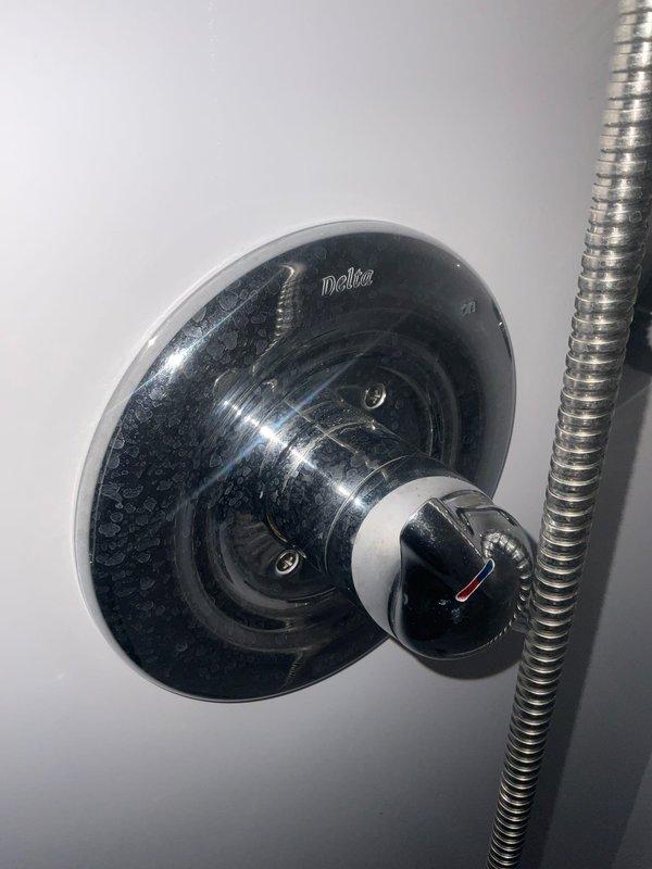 Responded to multiple plumbing issues throughout the residence. Assessed recurring frozen pipe situation in basement crawl space and documented conditions despite existing heat source and water shut-off protocols during extreme cold temperatures. Inspected first floor bathroom toilet fill valve experiencing intermittent refill issues requiring manual adjustment, and examined Delta shower control valve and showerhead for post-shutoff dripping condition. Evaluated upstairs master bathroom shower door for water intrusion concerns to determine if caulking failure or other sealing issue was present. Inspected kitchen sink faucet experiencing intermittent leaking. Photographed shower control fixtures and components for documentation purposes.