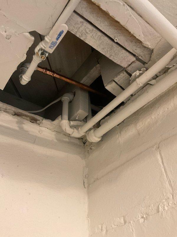 Responded to burst pipe emergency at century-old residential property. Accessed plumbing infrastructure through interior wall opening, where copper and PVC pipe connections were inspected and repaired. Exterior hose bib and associated piping mounted to brick foundation were also serviced to address water line failure and restore proper function to the plumbing system.
