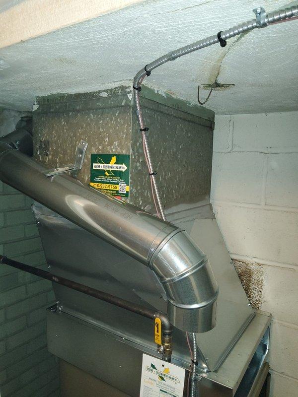Completed replacement of existing downflow furnace installation in basement mechanical room. Removed old unit and installed new furnace system with proper venting configuration, including stainless steel exhaust piping with 90-degree elbow termination. Added model 1410 component to system as specified. Installed electrical disconnect box on adjacent wall for code compliance and safe equipment operation. All ductwork connections secured to new unit, including metallic supply plenum integration. System tested and verified operational upon completion.