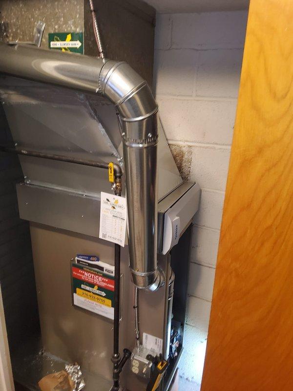 Completed replacement of existing downflow furnace installation in basement mechanical room. Removed old unit and installed new furnace system with proper venting configuration, including stainless steel exhaust piping with 90-degree elbow termination. Added model 1410 component to system as specified. Installed electrical disconnect box on adjacent wall for code compliance and safe equipment operation. All ductwork connections secured to new unit, including metallic supply plenum integration. System tested and verified operational upon completion.