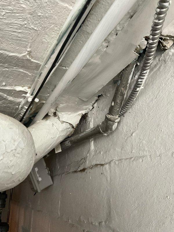 Completed comprehensive plumbing maintenance assessment of exposed ceiling-mounted pipe systems, including inspection of PVC supply lines, flexible metal conduit connections, and shutoff valve mechanisms. Documented deteriorating paint conditions on surrounding surfaces and pipe mounting integrity, photographing areas showing wear, peeling, and substrate exposure that may require future attention to prevent moisture intrusion or structural concerns.