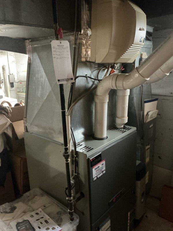 Responded to service call for air conditioning unit requiring refrigerant recharge. Upon arrival, conducted comprehensive system evaluation of existing HVAC equipment. Documented current installation including Trane furnace unit with associated ductwork, PVC condensate drainage system, and connected components. Performed visual inspection of mechanical room setup, noting equipment configuration and accessibility. Photographed existing system components for reference and assessment purposes. Based on findings and system age uncertainty, provided estimate for complete air conditioning system replacement rather than recharge service, as unit condition and specifications warranted full replacement consideration for optimal performance and efficiency.