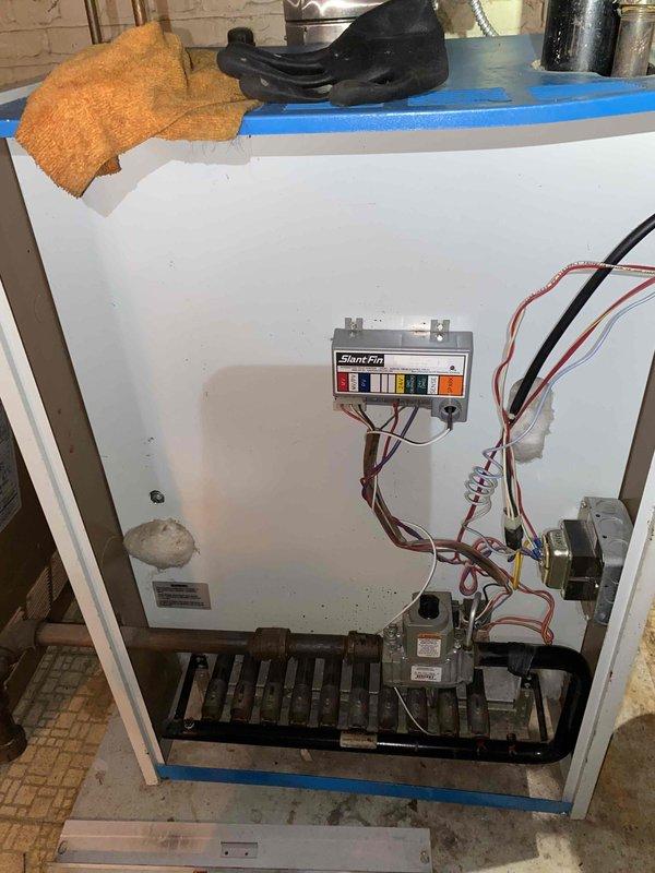 Performed annual maintenance on 20-year-old Slant/Fin boiler system. Removed front access panel to inspect internal components including burner assembly, heat exchanger, gas valve, and control board. Verified all electrical connections, wire bundles, and control circuits were secure and functioning properly. Conducted combustion analysis using digital diagnostic meter, recording stack temperature of 482°F and ambient temperature readings. All measured parameters including CO and CO2 levels were within acceptable operating ranges. Inspected gas piping, connections, and safety controls for proper operation. System tested and returned to normal service with all components operating as designed.