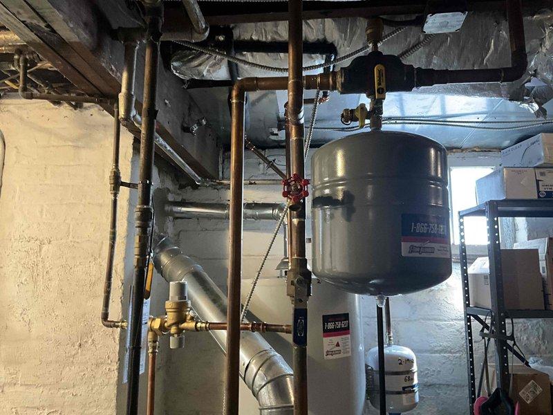 Conducted boiler estimate after detecting elevated carbon monoxide levels during inspection. Thorough examination revealed heat exchanger in severely deteriorated condition, posing immediate safety hazard and requiring system replacement. Documented equipment condition with photographs showing existing HVAC infrastructure including Unico System components, ductwork, water heater, and associated plumbing connections for replacement planning purposes.