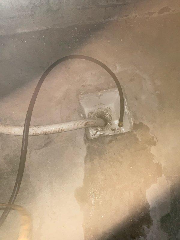 Responded to water heater failure resulting in significant basement flooding. Upon arrival, found extensive water accumulation on concrete floor with dark staining indicating prolonged moisture exposure. Deployed portable vacuum pump with drainage hoses to extract standing water from affected area. Connected discharge lines to floor drain for proper water removal. Coordinated with HVAC technician scheduled for same-day service to address air conditioning system following water heater assessment. Water heater exhibited signs of tank failure requiring immediate attention to prevent further flooding damage.