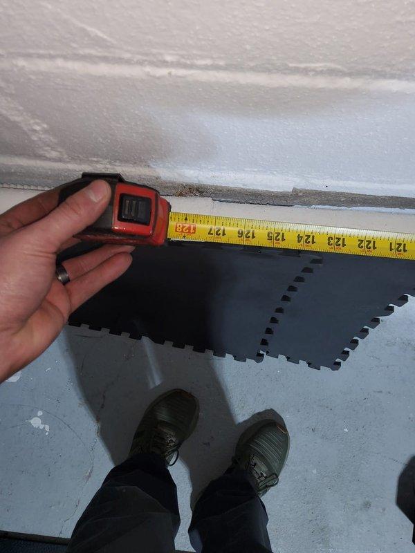 Responded to water leak at return line joint that was recently replaced. Upon arrival, found active leak at pipe connection with bucket positioned to catch dripping water and visible floor staining indicating ongoing moisture issue. Inspected joint connection on copper return line where it meets insulated vertical pipe assembly. Repaired leaking joint by properly sealing and securing the connection point to eliminate water discharge. Verified repair held pressure and no further leakage was present upon completion.