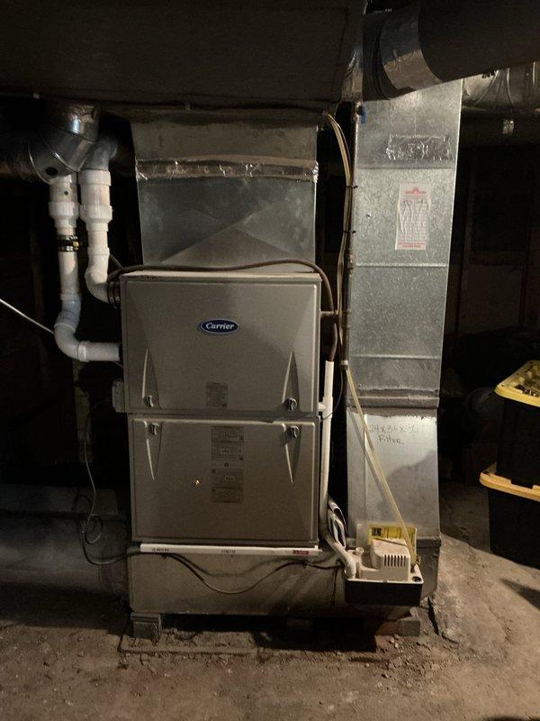 Conducted on-site evaluation for add-on air conditioning system to existing forced air heating setup. Assessed current Carrier furnace installation and existing ductwork infrastructure in basement mechanical room to determine compatibility and requirements for AC integration. Documented existing HVAC configuration including supply ductwork, PVC drainage lines, and available space for evaporator coil placement above furnace unit. Evaluated structural conditions of ceiling joists showing water damage and deterioration that may require attention during installation. Provided comprehensive estimate for complete air conditioning system addition including necessary ductwork modifications, electrical requirements, condensate drainage integration with existing PVC system, and outdoor condenser unit placement.