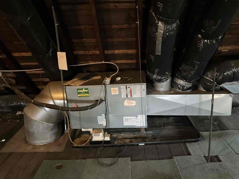Completed estimate for air conditioning system replacement and addition. Assessed existing HVAC unit located in attic space and evaluated installation requirements for new mini-split system to serve first floor. Documented current equipment configuration, ductwork layout, and available space for proposed installations. Photographed outdoor area for potential condenser placement and interior mechanical systems to determine scope of work needed for dual system installation.