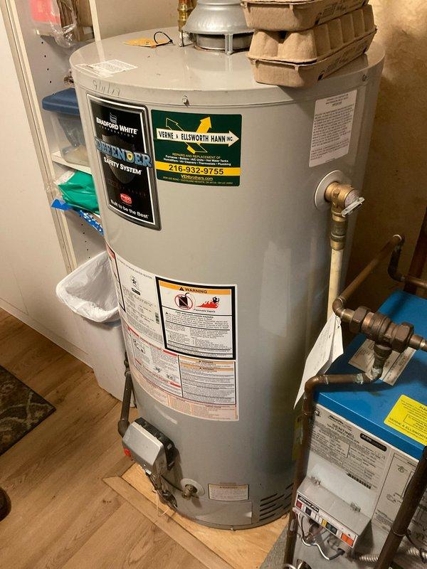 Completed routine home plan plumbing inspection on a 10-year-old Defender Safety System tanked water heater. Assessed overall unit condition, verified proper operation of temperature controls and pressure relief valve, inspected all visible plumbing connections including copper supply lines and brass fittings, and documented equipment status with photographic records. Unit found to be operational with normal age-related wear present.