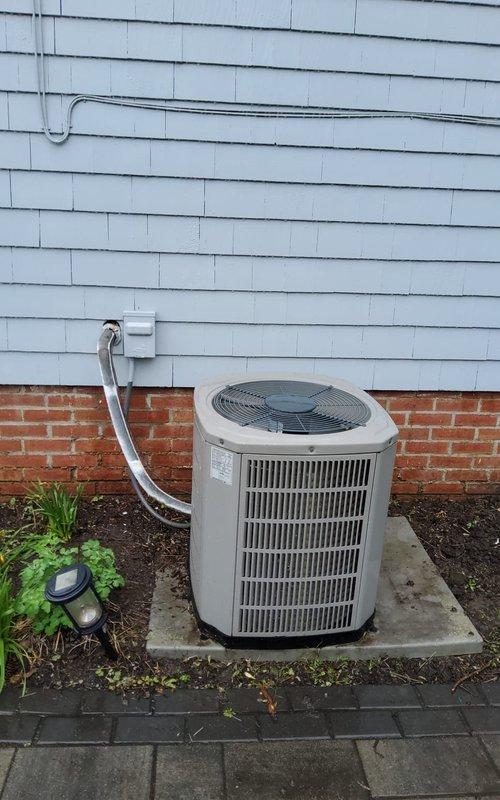 Completed comprehensive maintenance service on residential forced-air heating and cooling system. Performed thorough inspection of indoor furnace unit and air handler located in basement utility area, verified proper operation of all internal components with access panel open for detailed examination. Checked electrical connections, control boards, and safety systems for proper function. Inspected white PVC condensate drain lines and venting system for proper drainage and secure connections. Evaluated outdoor air conditioning condenser unit mounted on concrete pad, assessed refrigerant line set routing and insulation integrity from exterior unit through wall penetration to indoor equipment. Verified electrical disconnect box and power supply connections at outdoor unit. Confirmed proper airflow through condenser coil fins and fan operation. System operating within normal parameters with no immediate repairs required at time of service.