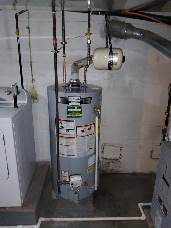 Responded to service call for 20-year-old Bradford White gas water heater that was completely non-operational with pilot light failure. Upon inspection, determined the unit had reached end of service life and was beyond economical repair. Removed and properly disconnected the failed Bradford White gas water heater from existing gas line, water supply, and venting system. Installed new AO Smith residential gas water heater with appropriate BTU capacity for the home. Connected all copper supply and discharge lines with brass fittings, installed expansion tank, and established proper venting per manufacturer specifications and local code requirements. Tested all connections for gas leaks, verified proper pilot ignition and burner operation, and confirmed adequate hot water delivery throughout the home's plumbing system. All work completed in century-old home's basement utility area with no water damage present.