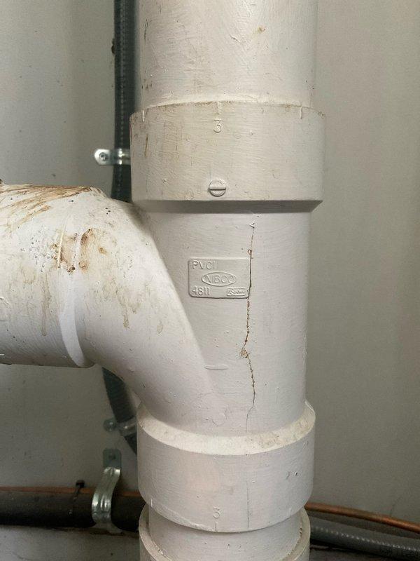 Responded to main drain backup in basement. Upon arrival, found floor drain with significant debris buildup and discoloration indicating chronic drainage issues. Performed main drain cleanout through accessible cleanout fitting on vertical PVC drain line. Cleared blockage from main sewer line, restoring proper drainage flow. Tested system to confirm backup was resolved and drain was functioning properly.