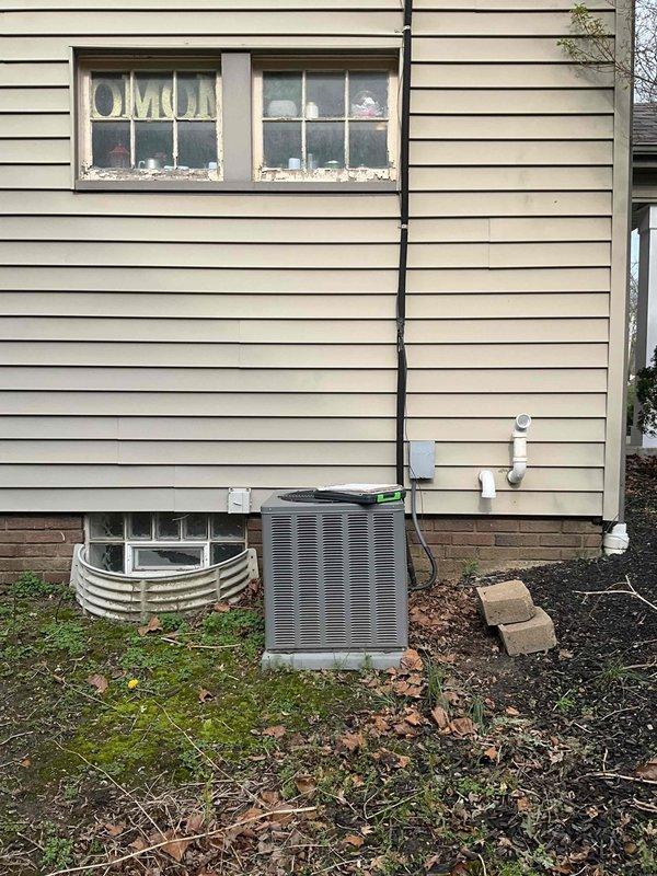 Conducted on-site evaluation for mini split system installation to address recurring cooling concerns. Assessed existing HVAC infrastructure including outdoor condensing unit with refrigerant line routing along exterior siding, and reviewed current thermostat setup showing system in off position. Documented equipment placement, electrical connections, and potential installation locations for ductless mini split components to provide comprehensive estimate for system upgrade.